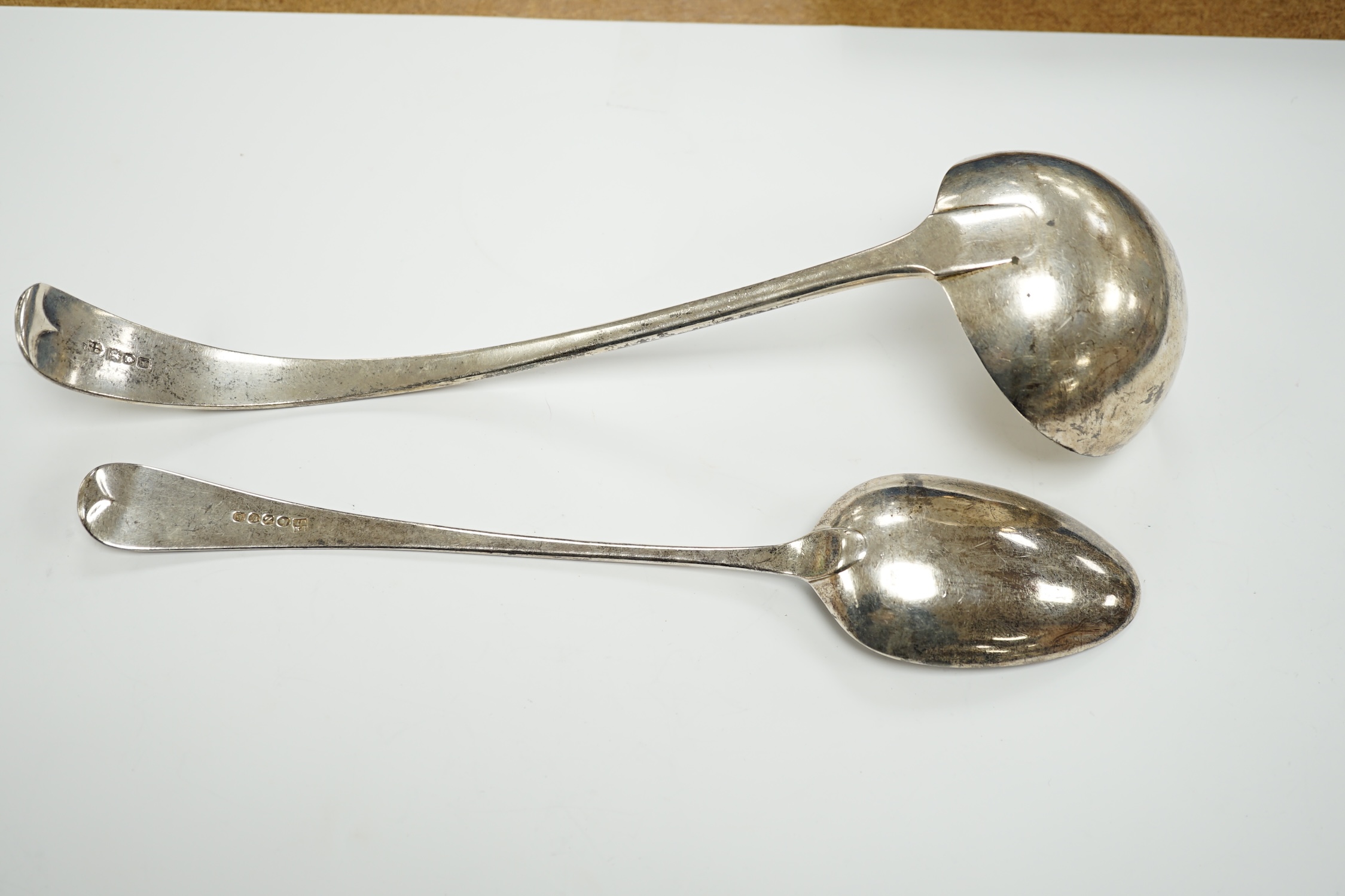 An Edwardian silver Old English pattern soup ladle, London, 1902 and a George III basting spoon, London, 1808, 12.8oz.
